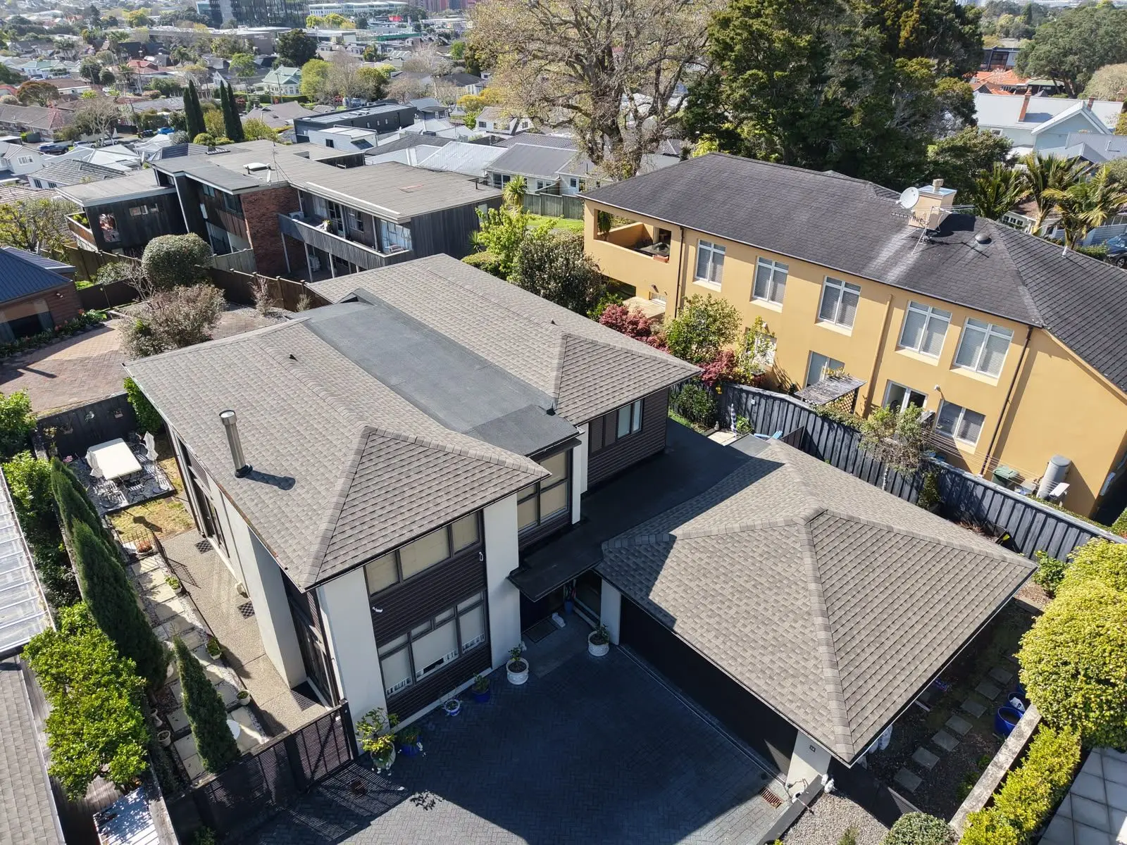 Aerial view of completed asphalt shingle roofs in an Auckland suburb