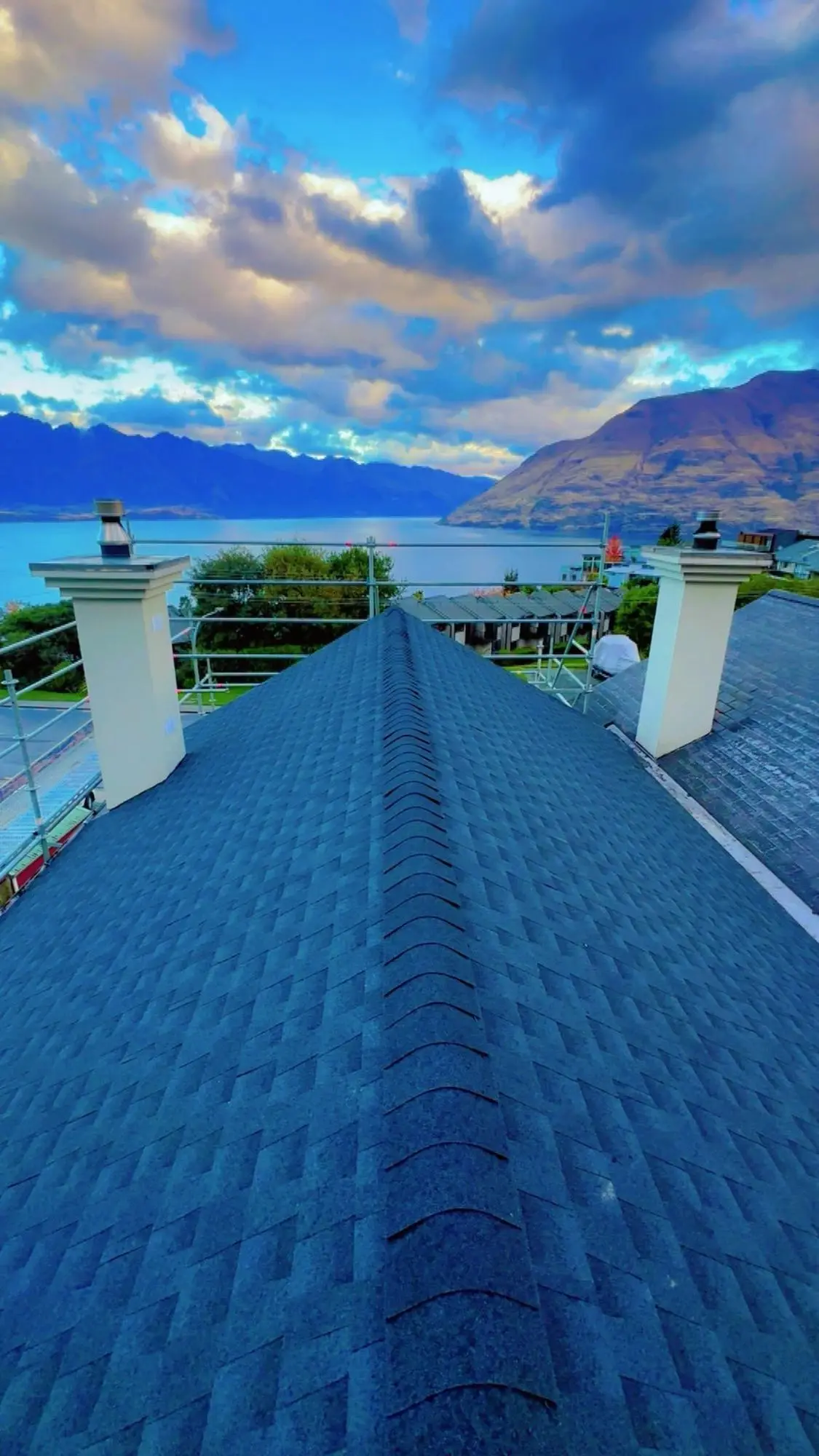 Asphalt shingle roof ridge with a lake and mountain outlook