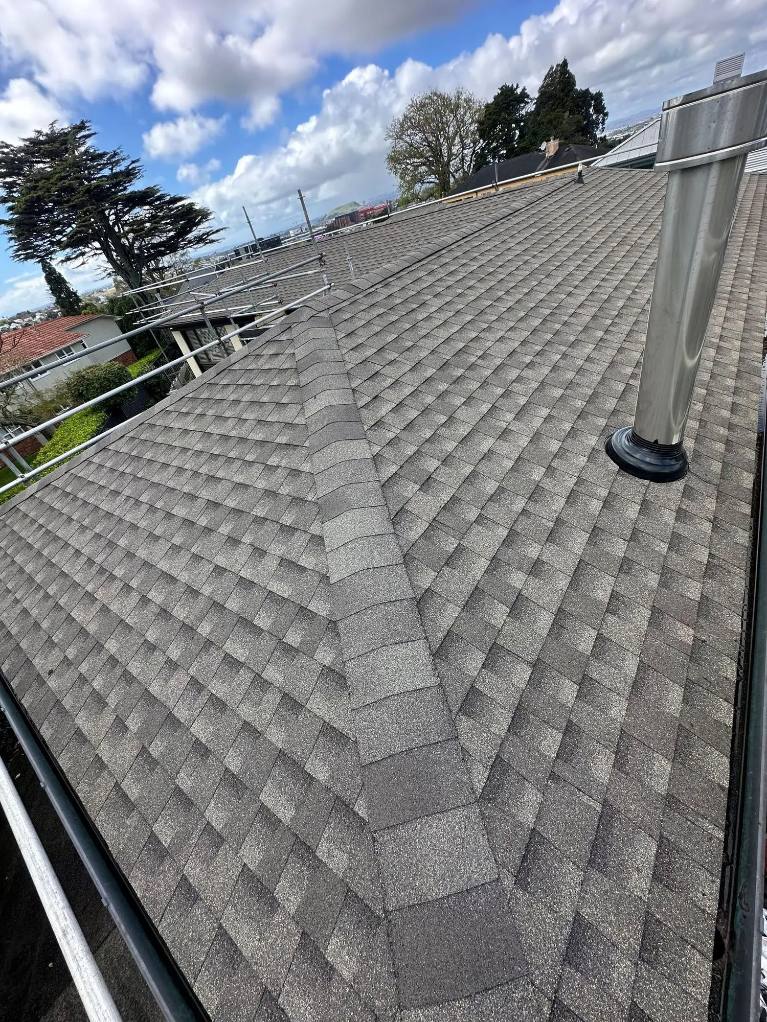 Completed asphalt shingle roof viewed up the slope on an Auckland home