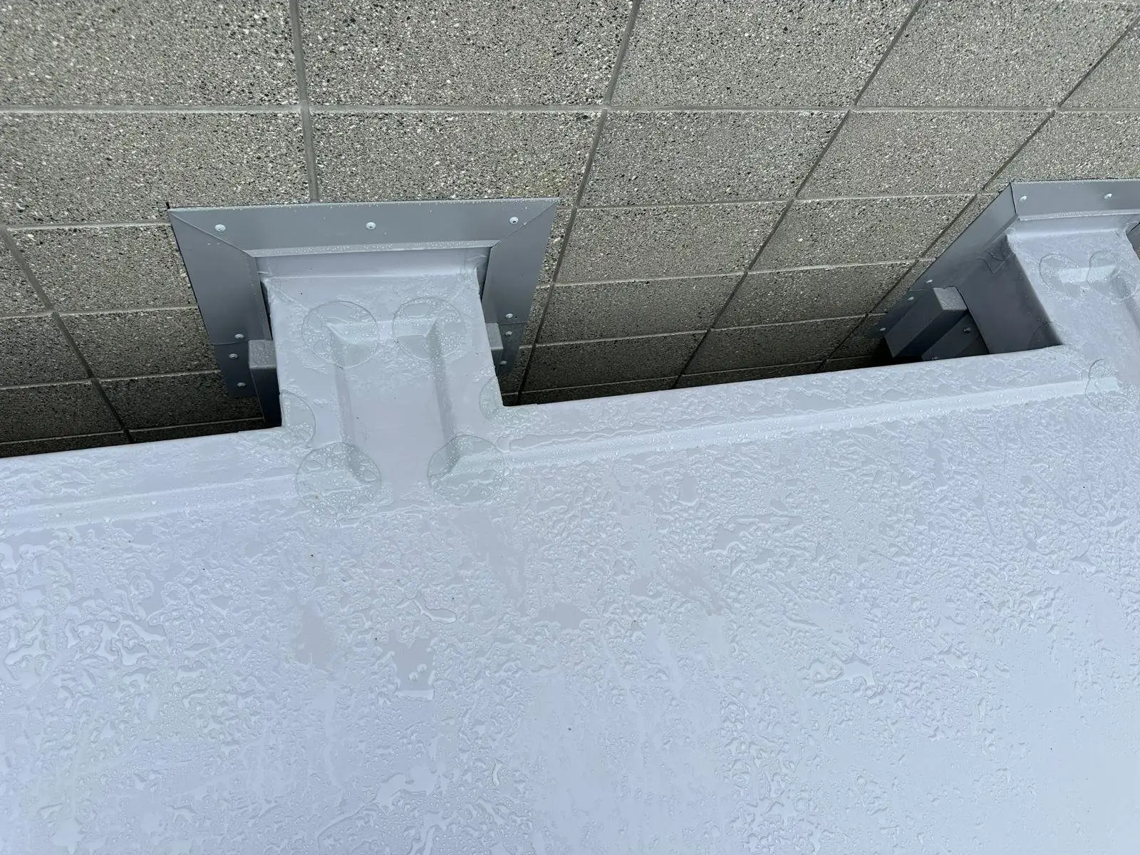 Custom scupper flashing folded and installed through a block wall