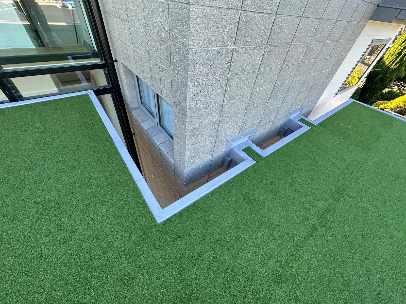 Membrane upstand detail where a turf deck meets a block wall